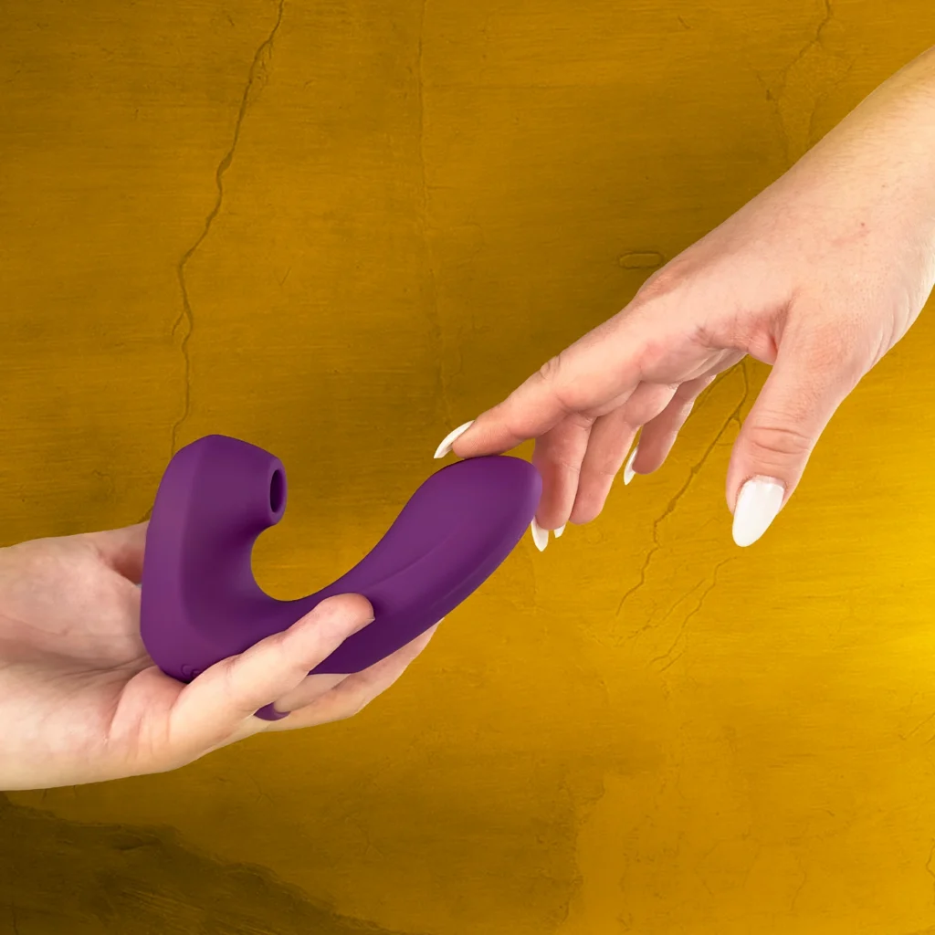 Image showing a lavender color Air touch clitoral suction in between the two women's hand
