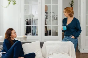 Two women in a cozy home setting having a casual conversation over coffee, discussing how to maintain libido during perimenopause naturally.