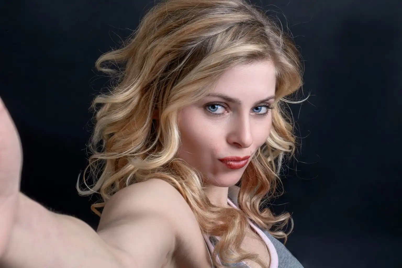 Confident woman in a white tank top looking into the camera, symbolizing self-empowerment and breaking myths about virginity and sexual purity.