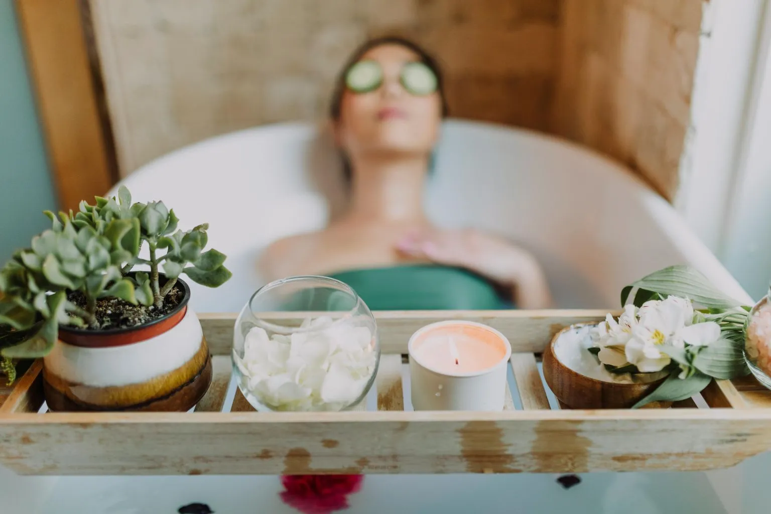 Woman relaxing in a bathtub surrounded by candles and plants, practicing self-care and learning how to improve blood flow for women naturally.