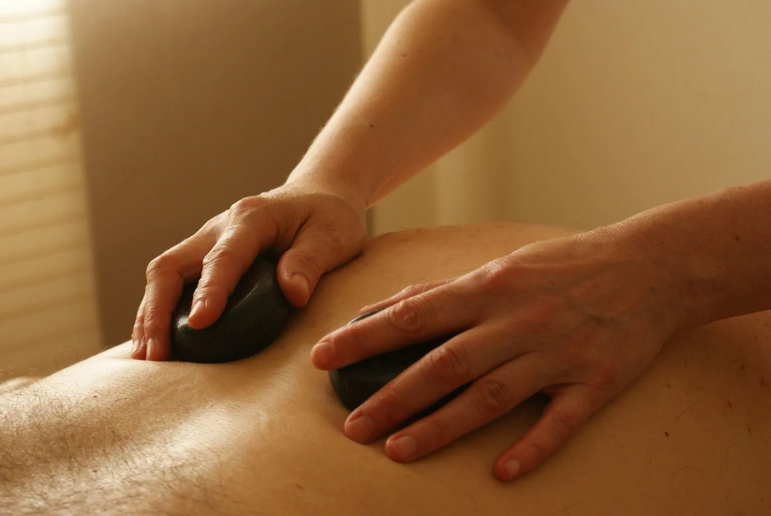 A couple enjoying a relaxing body massage with a warm ambiance, using the best body massager for intimacy and relaxation to create a soothing, intimate moment.