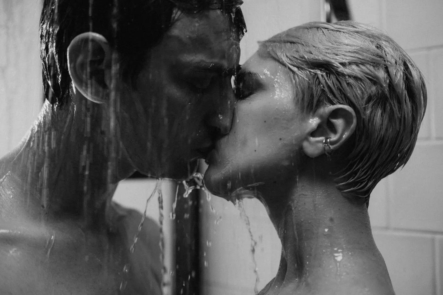 Romantic couple kissing in the shower while exploring intimacy with waterproof couple vibrators for shower play.